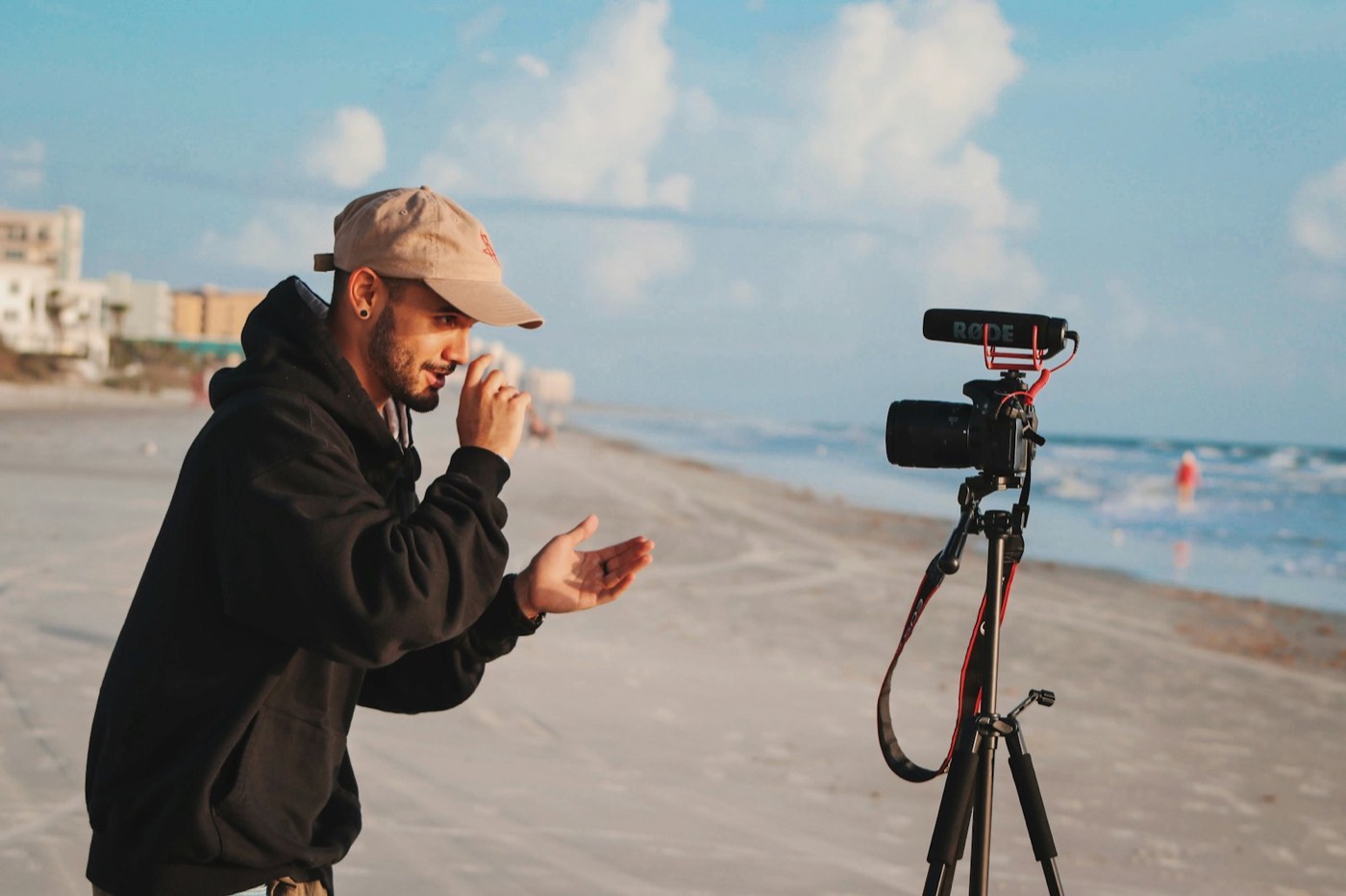 Camera operator filming on a beach